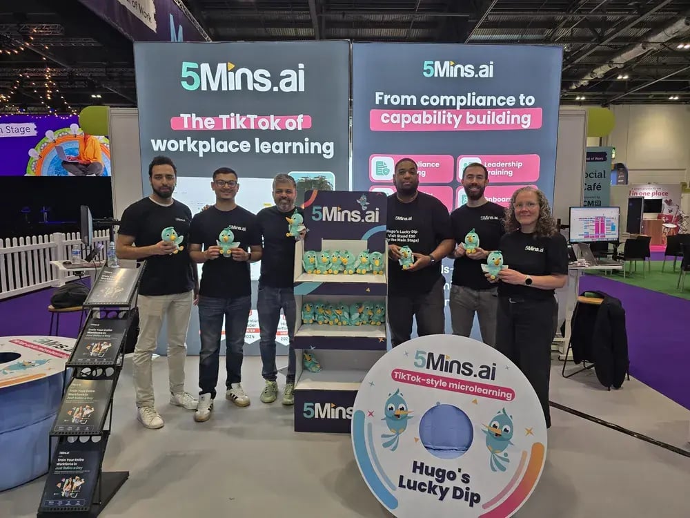 The 5Mins team holding Hugo plush toys on their stand at the CIPD Festival of Work 2026